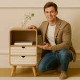 Man posing with a wooden side table against a beige wall.